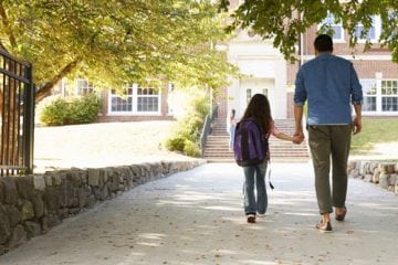 A father and daughter walking to school