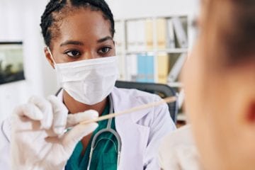 Woman administers COVID test. How accurate are COVID test results?