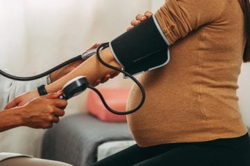 A doctor measures the blood pressure of a pregnant person