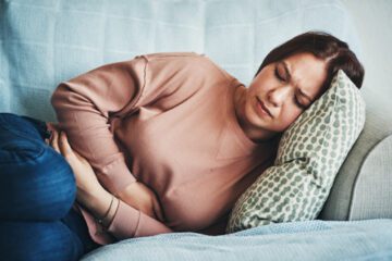Person lying down holding stomach