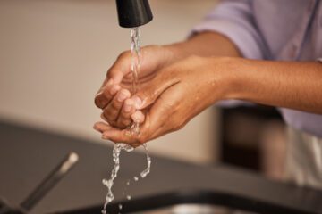 A person washing their hands to be cautious about what causes food poisoning.
