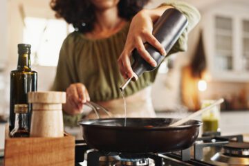woman pouring seed oil into pan